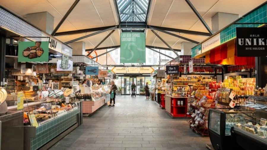 Copenhagen indoor market with diverse stalls, fresh produce, gourmet items, and international delicacies.