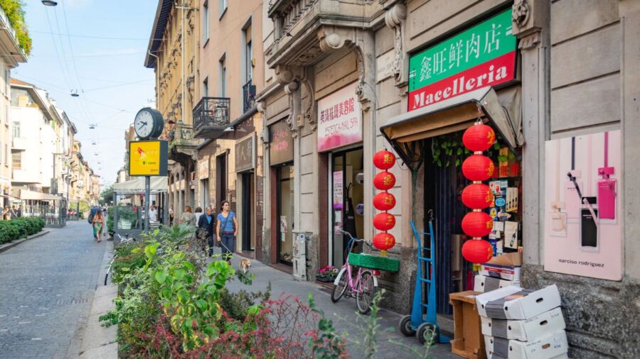 Vibrant urban street scene with European architecture, diverse cultures, bustling community, and greenery.