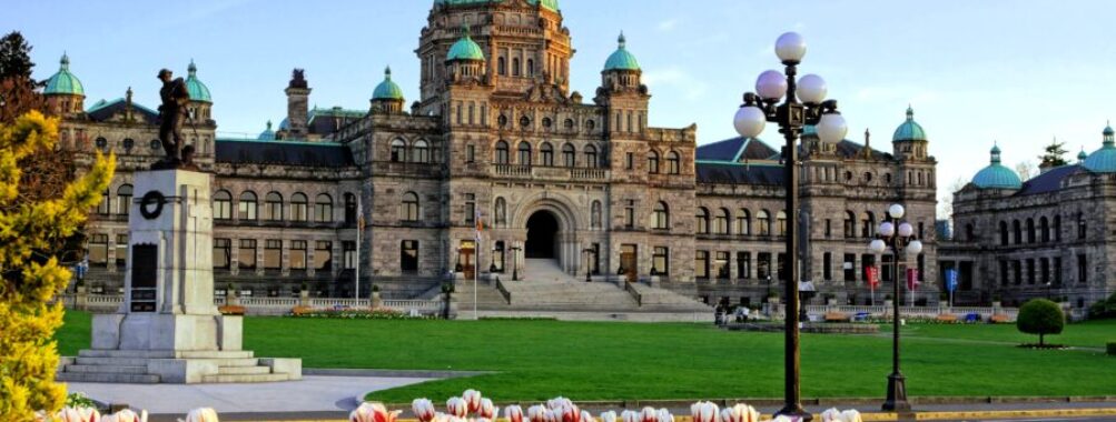 The British Columbia provincial parliament building framed by colorful spring tulips in Victoria, BC, Canada
