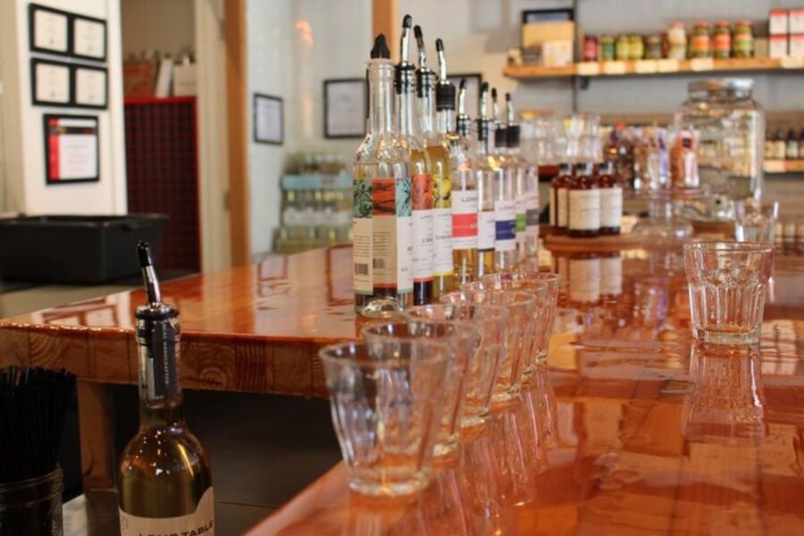 Well-stocked bar with various bottles and glasses, part of the Victoria Craft Brewery and Distillery Guided Tour.