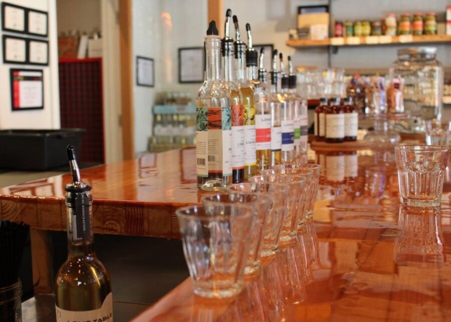 Long bar counter filled with various bottles, showcasing the offerings at Victoria Craft Brewery and Distillery.