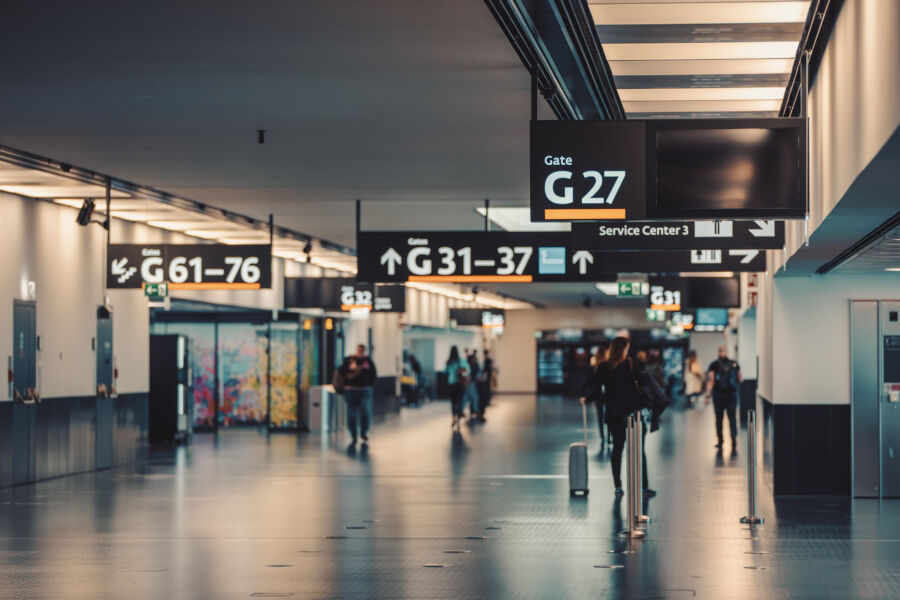 Travelers walking with luggage in the bustling terminal of Vienna Airport