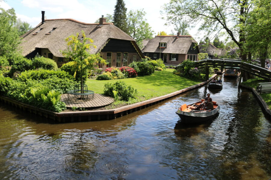Giethoorn village, Netherlands: thatched cottages along canal with whisper boat.
