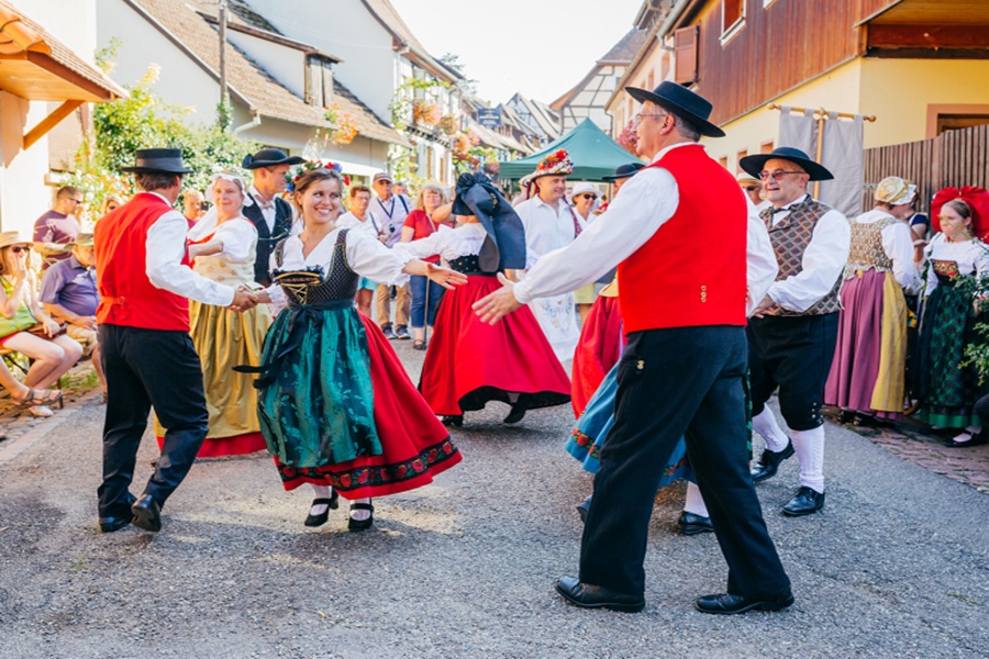 Alsace wine festival folk dance in village street with traditional costumes.