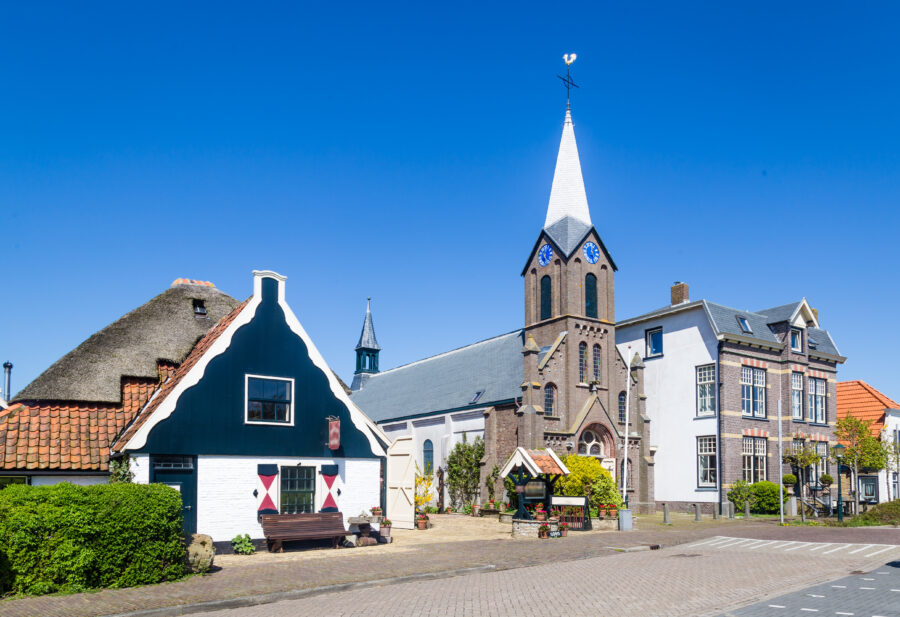Scenic view of Oudeschild village on Texel, showcasing Martinus church and charming gable-roofed houses.