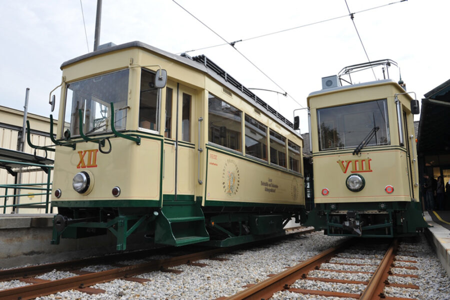 Vintage cream-and-green heritage trams XII and VIII at Poestlingbergbahn station.