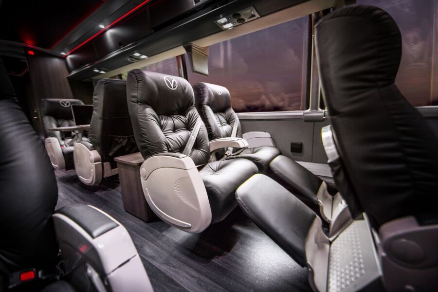 Interior view of a Vonlane Bus featuring spacious black leather seats arranged for passenger comfort.