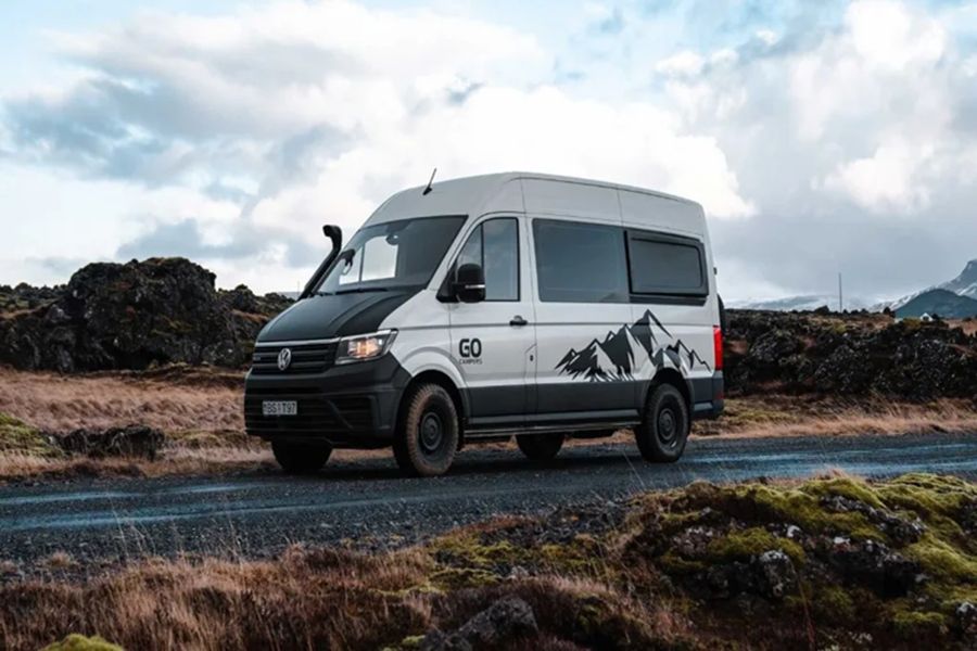 Volkswagen campervan on scenic rugged road, perfect for adventurous travel and exploration.
