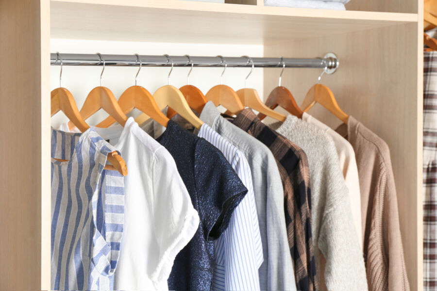 Wardrobe closet filled with various clothes, featuring licensed hangers for organized storage