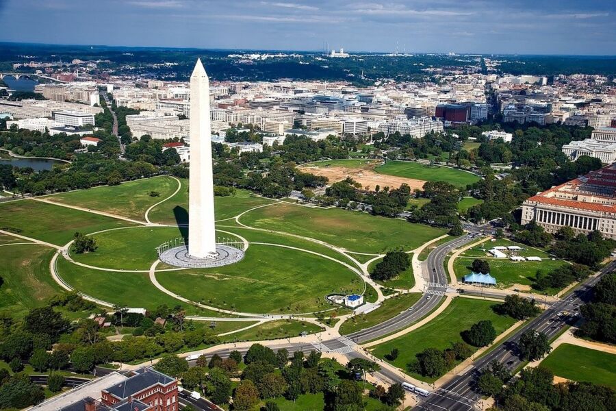 Washington DC Monument, a tall obelisk, stands against a clear blue sky, symbolizing national pride and history.
