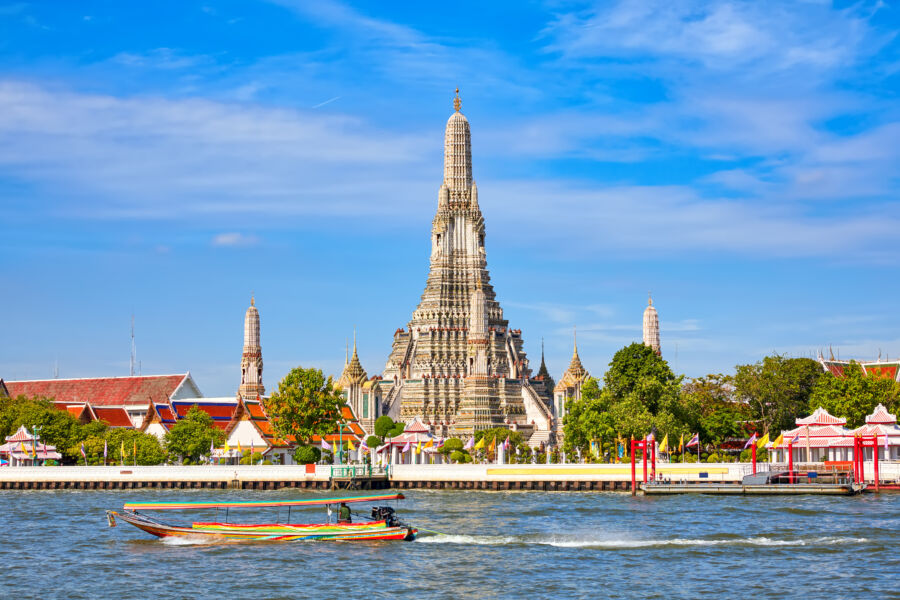 The Temple of Dawn, or Wat Arun, features stunning spires and intricate designs, located on the banks of the Chao Phraya River in Bangkok