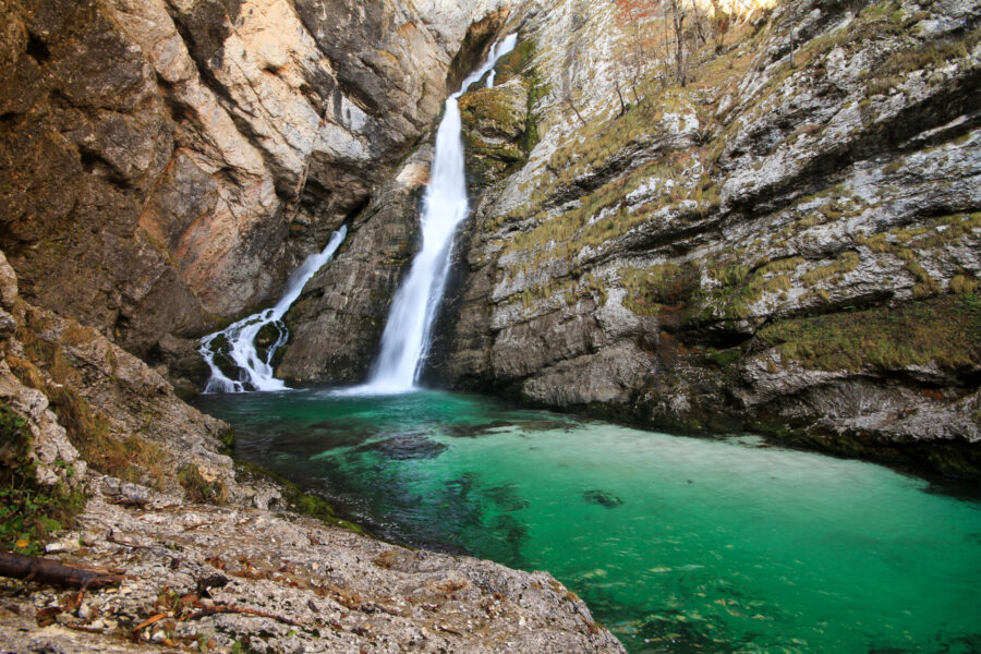 Savica Falls waterfall in Slovenian limestone gorge with emerald plunge pool.
