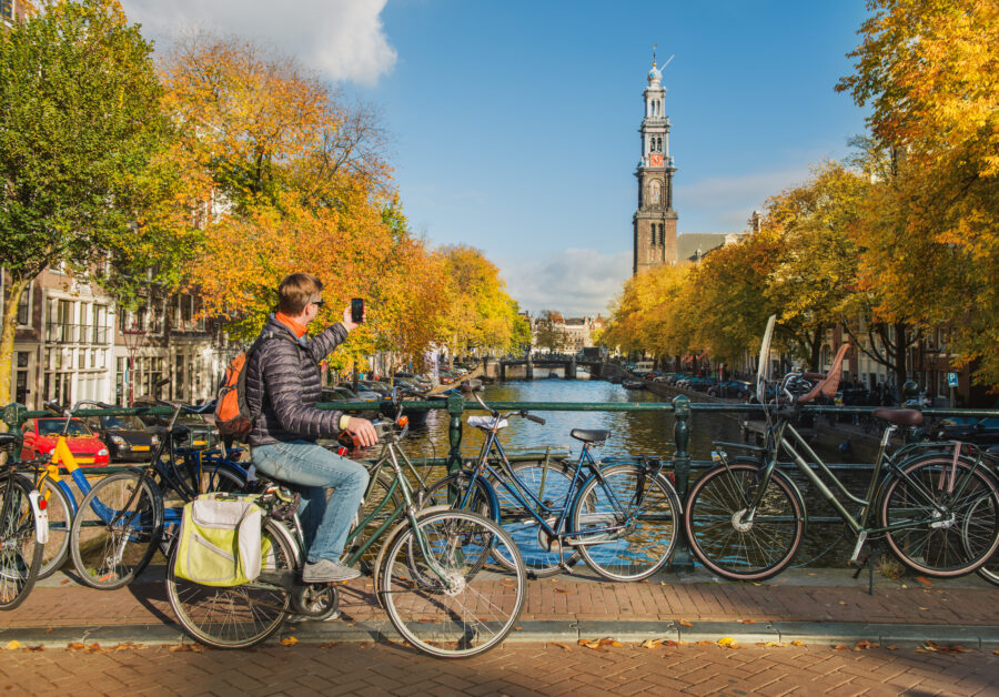 Traveler taking a picture of the Westerkerk, showcasing its impressive architecture and iconic bell tower.