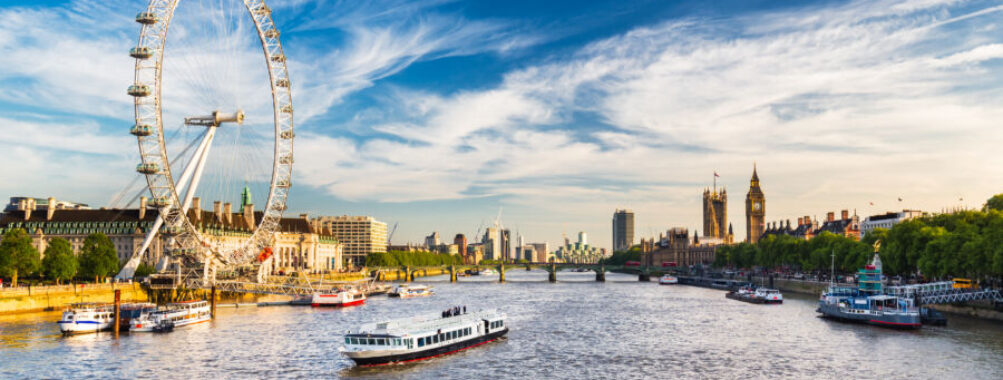 The iconic Westminster Parliament building alongside the River Thames, showcasing its Gothic architecture and scenic surroundings.