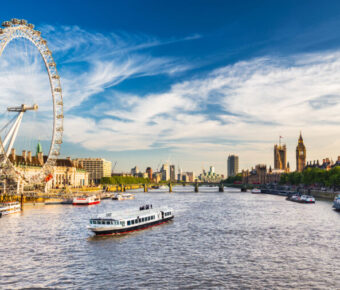 The iconic Westminster Parliament building alongside the River Thames, showcasing its Gothic architecture and scenic surroundings.