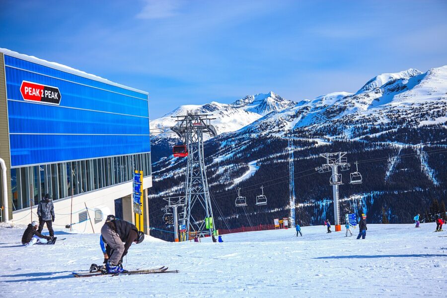 Snowboarder descends a slope at Whistler-Blackcomb, showcasing winter sports excitement and mountain scenery.