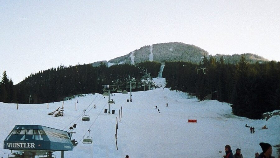 Ski lift stands on a snow-covered slope at Whistler Creekside, Canada, surrounded by winter scenery.
