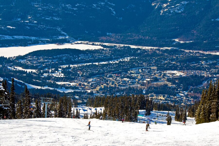 Skiers enjoy a snowy mountain landscape in Whistler Village, British Columbia, Canada, showcasing winter sports activity.