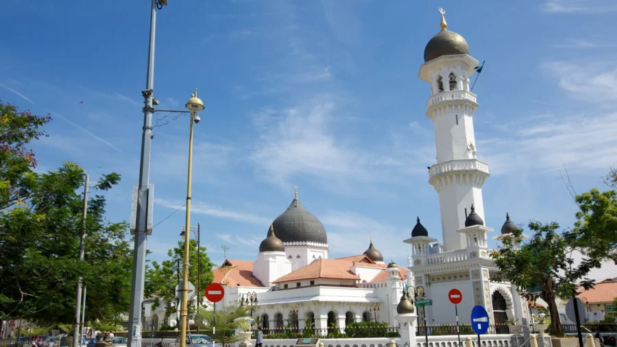 Kapitan Keling Mosque with white minaret, domes and city street view in Penang, Malaysia.