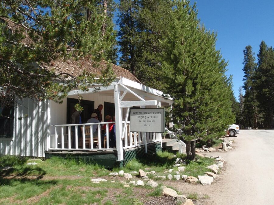 White Wolf Lodge, a white house featuring a porch, set in the scenic Yosemite National Park.