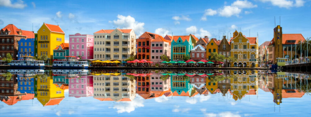 Colorful colonial buildings line the waterfront in Willemstad, Curaçao, showcasing vibrant architecture and Caribbean charm