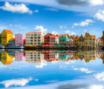 Colorful colonial buildings line the waterfront in Willemstad, Curaçao, showcasing vibrant architecture and Caribbean charm