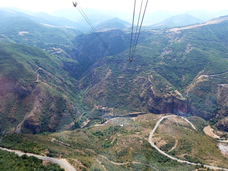 The Wings of Tatev cable car glides over a scenic mountain view in Armenia.
