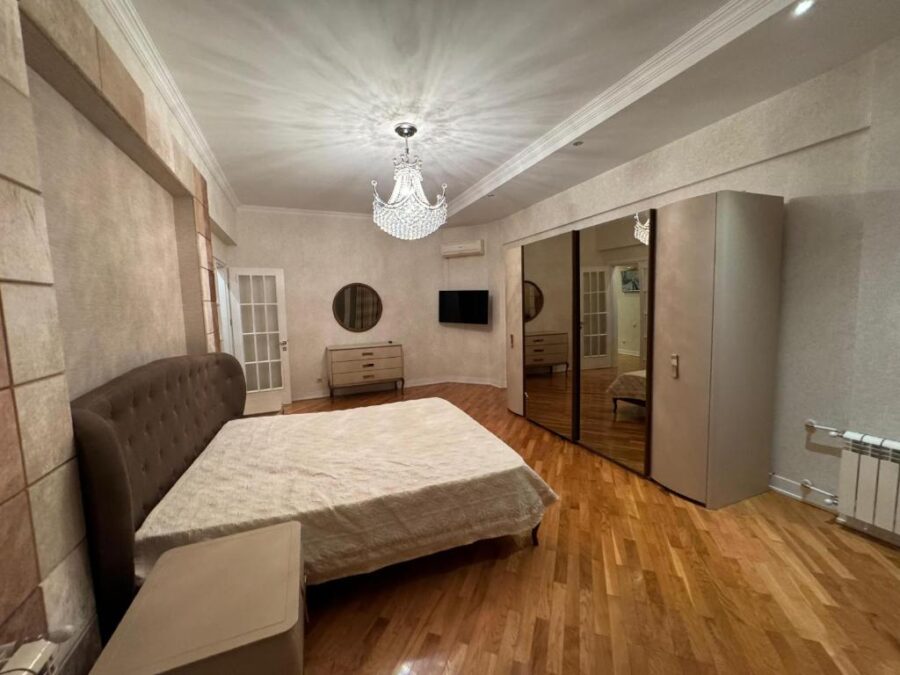 Cozy bedroom at Winter Park Hotel Baku featuring a bed, dresser, and mirror, designed for comfort and relaxation.