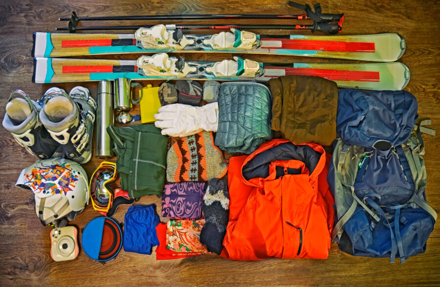 Collection of winter sports equipment, including ski clothes and various accessories for skiing and snowboarding