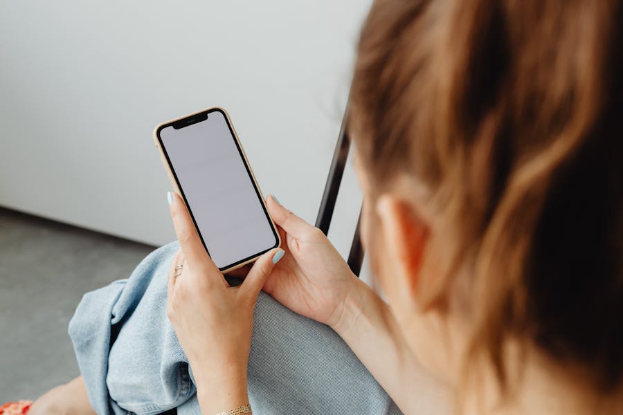 Woman with smartphone, relaxed setting, eSIM troubleshooting, casual style, ambient lighting.