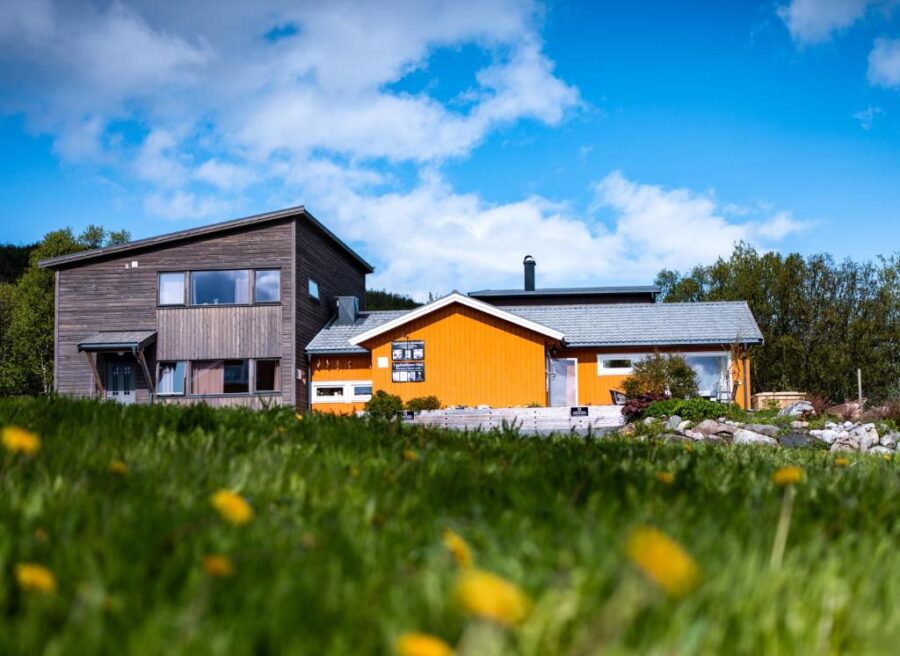 Yggdrasil Farmhotel Retreat features a house with a striking yellow and orange exterior in Norway.
