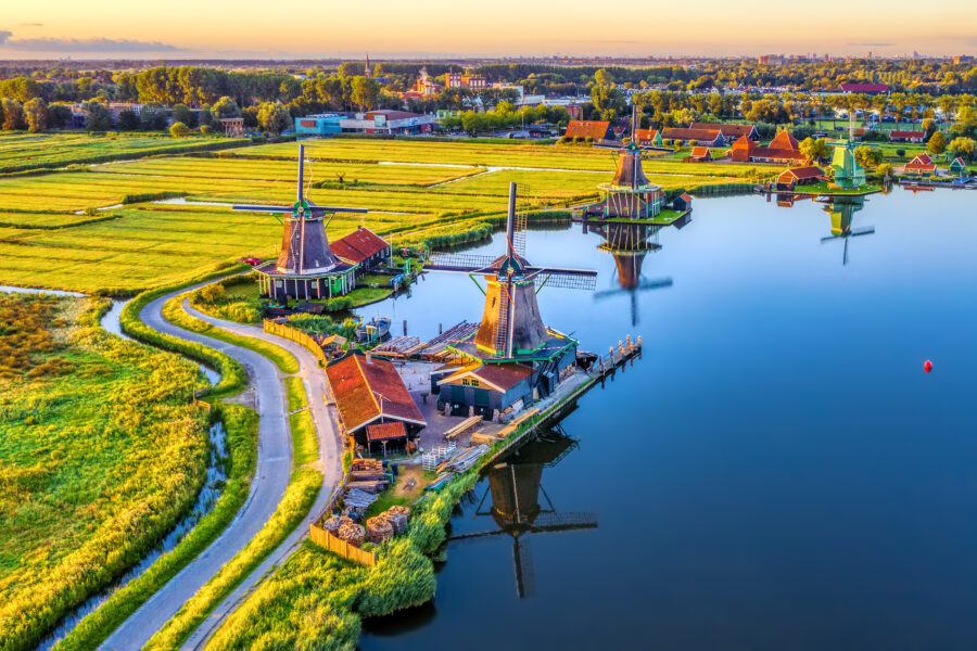 Aerial view of Zaanse Schans showcasing traditional windmills and lush green fields in North Holland, Netherlands.