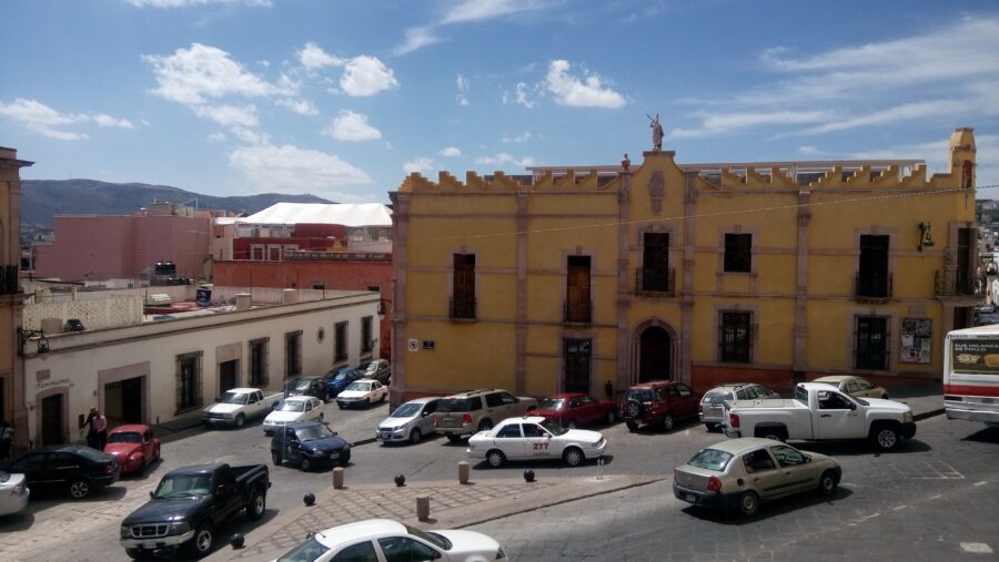 Vehicles parked in Plaza de Santo Domingo, showcasing the vibrant atmosphere of Zacatecas, Mexico