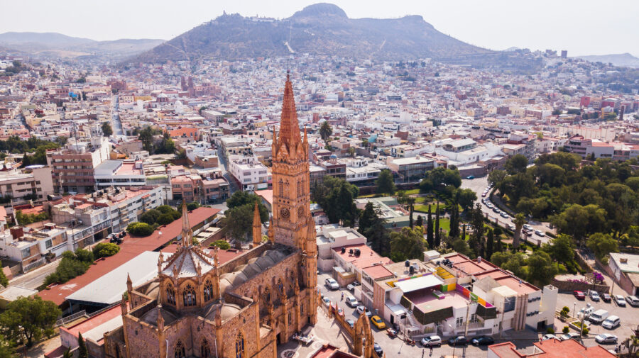 Aerial view of Zacatecas City skyline, showcasing urban architecture and landscape under clear daytime skies
