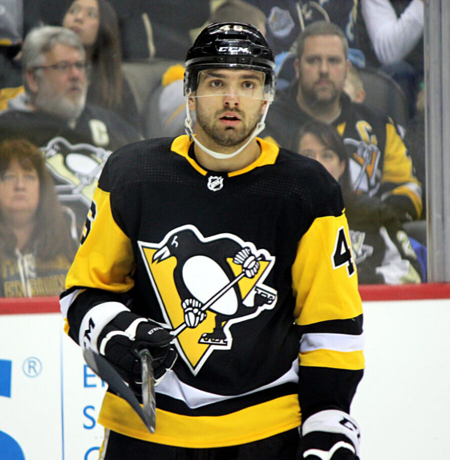 Zach Aston-Reese, a professional ice hockey player, skating on the ice in team uniform during a game.
