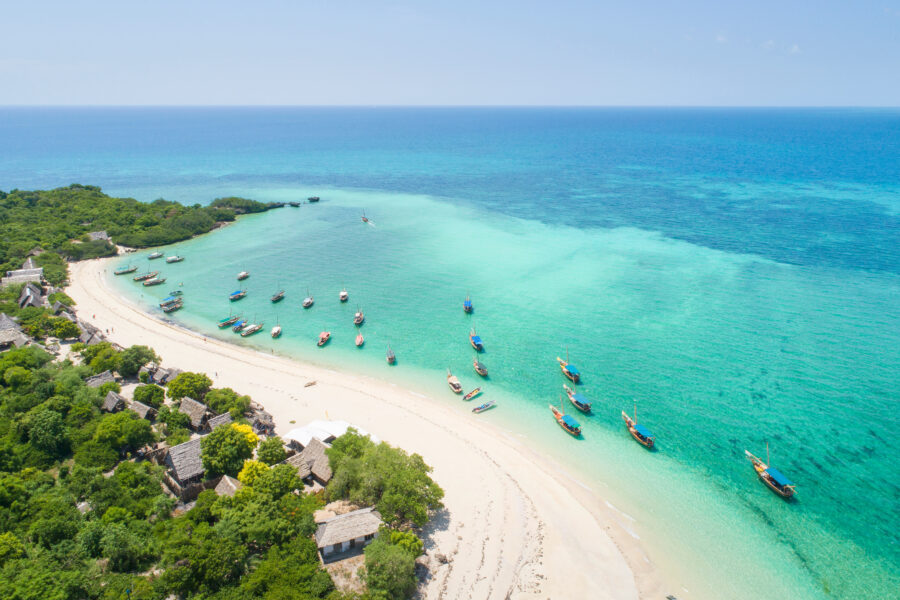 Boats along the curvy coast and beautiful beach on the island of Zanzibar