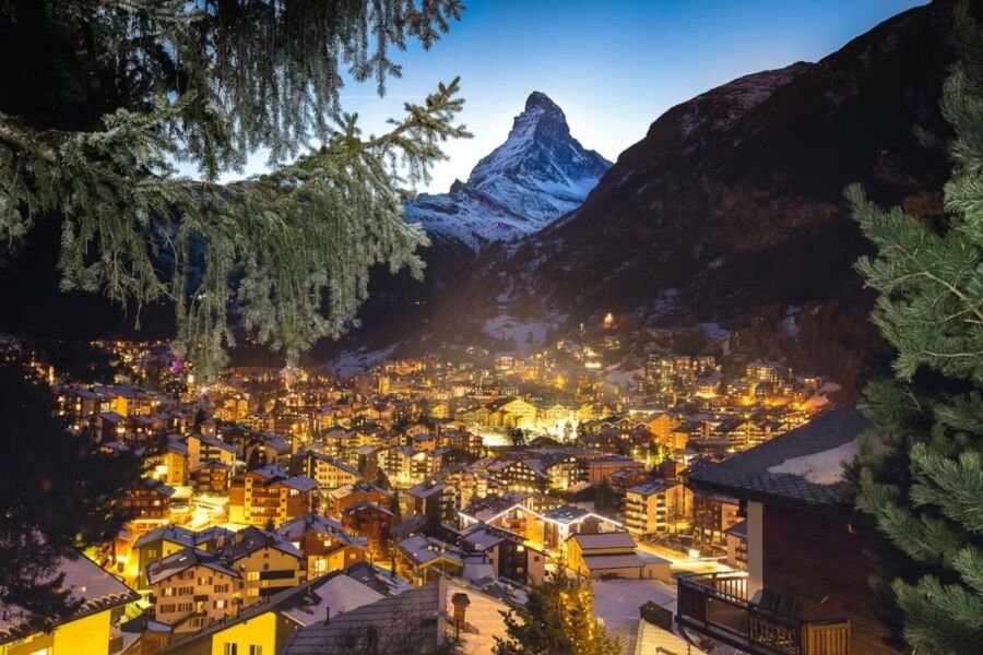 The Matterhorn covered in snow, illuminated at night during a Christmas walking tour in Zermatt, Switzerland.
