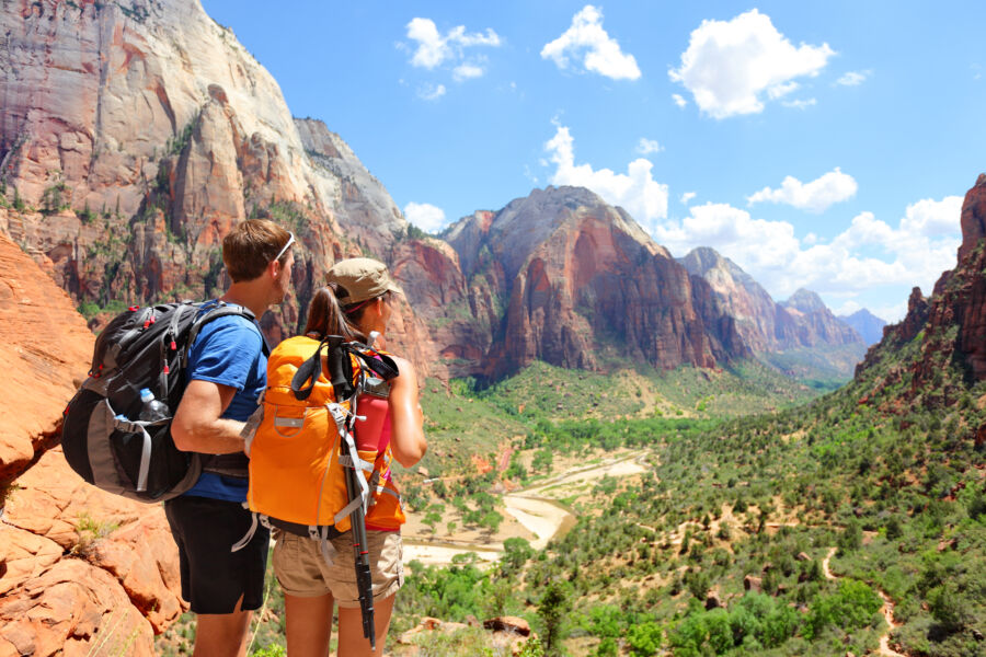 Hikers enjoying a scenic view at Zion National Park, surrounded by stunning rock formations and lush greenery