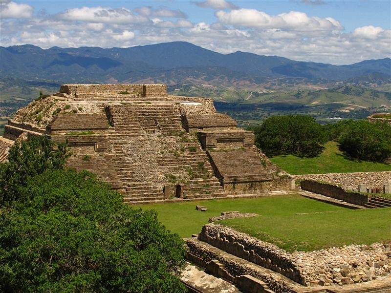 The ancient ruins of Zona Arqueológica de Monte Albán, showcasing stone structures against a clear blue sky.
