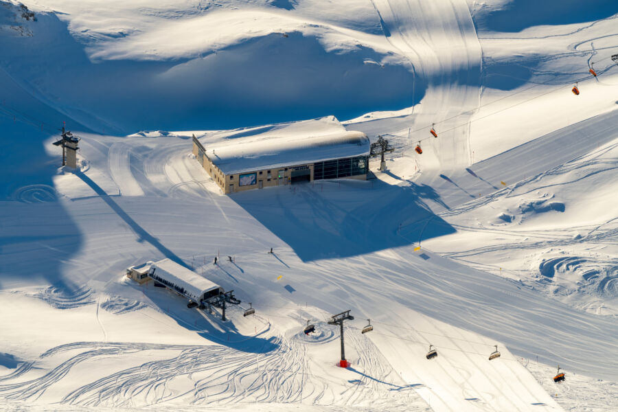 Winter view of Zugspitze glacier with cable car, mountain range, and sunrise glow in Garmisch-Partenkirchen, Bavaria
