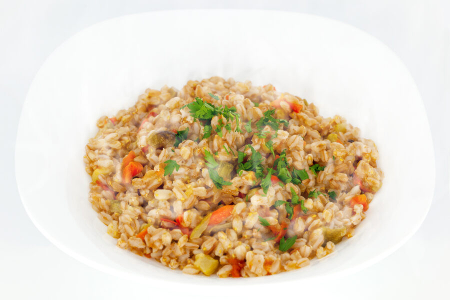Close-up of Zuppa di farro, a hearty soup featuring farro grains, vegetables, and herbs in a rustic bowl. 