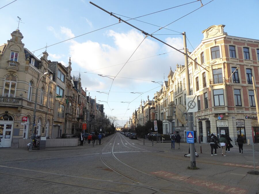 Busy street in Zurenborg, Antwerp, filled with pedestrians and cars, showcasing vibrant urban life.