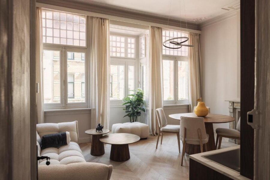 Cozy living room at Zurenborg Suites featuring a table, chairs, and a comfortable couch.
