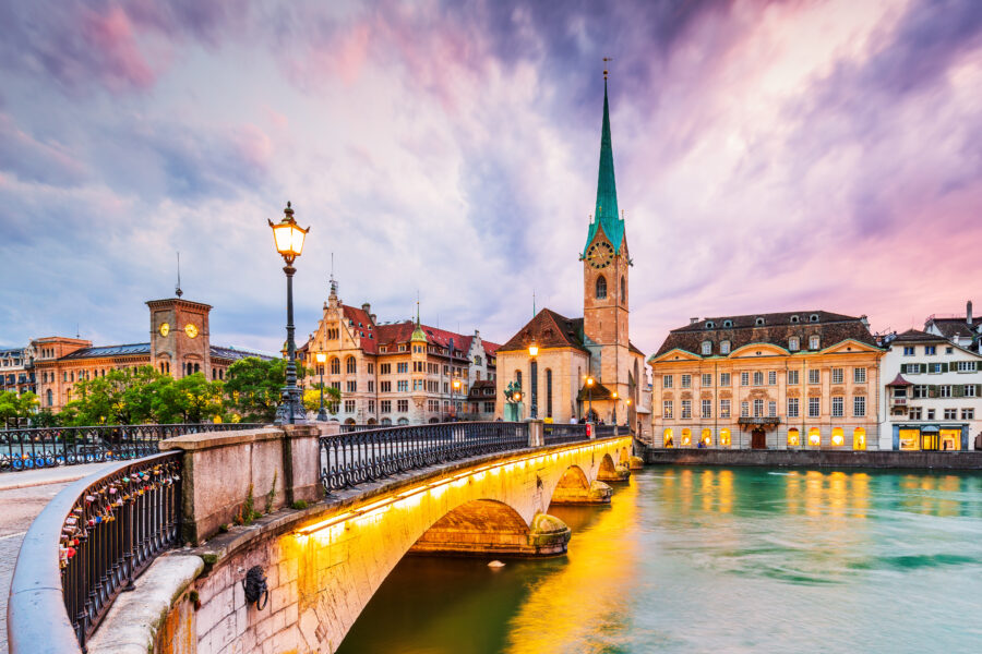 Scenic view of Zurich's city center with the renowned Fraumünster Church beside the Limmat River.
